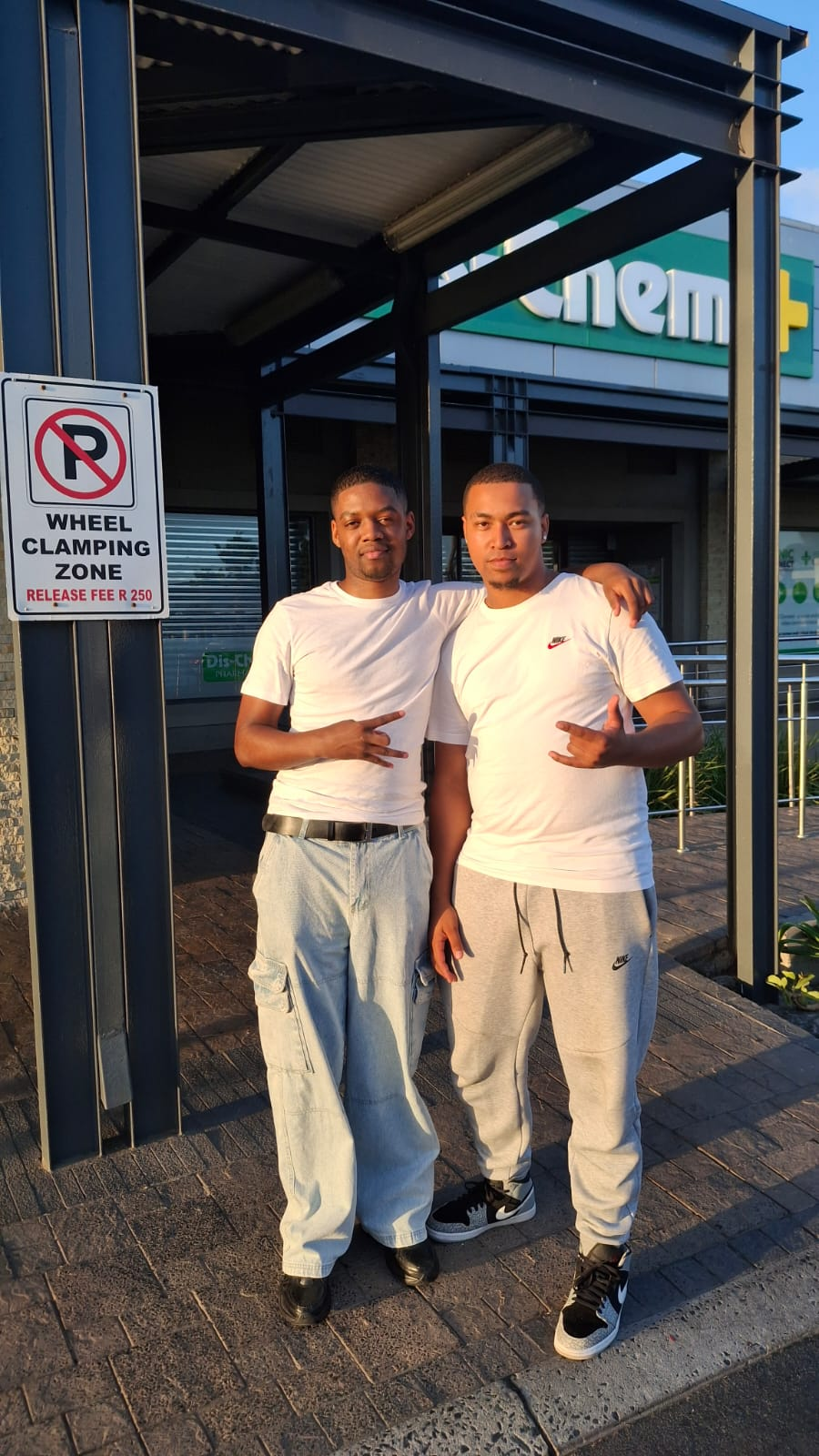 Two friends standing together outside a shop